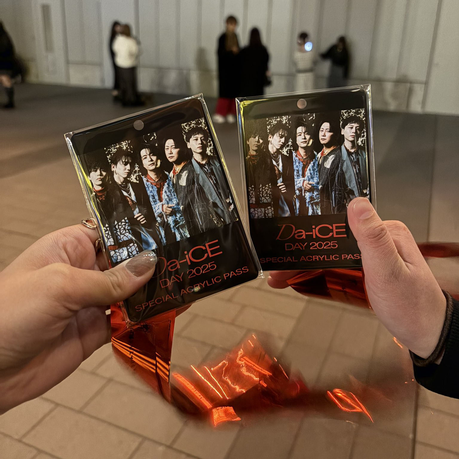 二人で銀テープとアクリルプレートを持っている写真