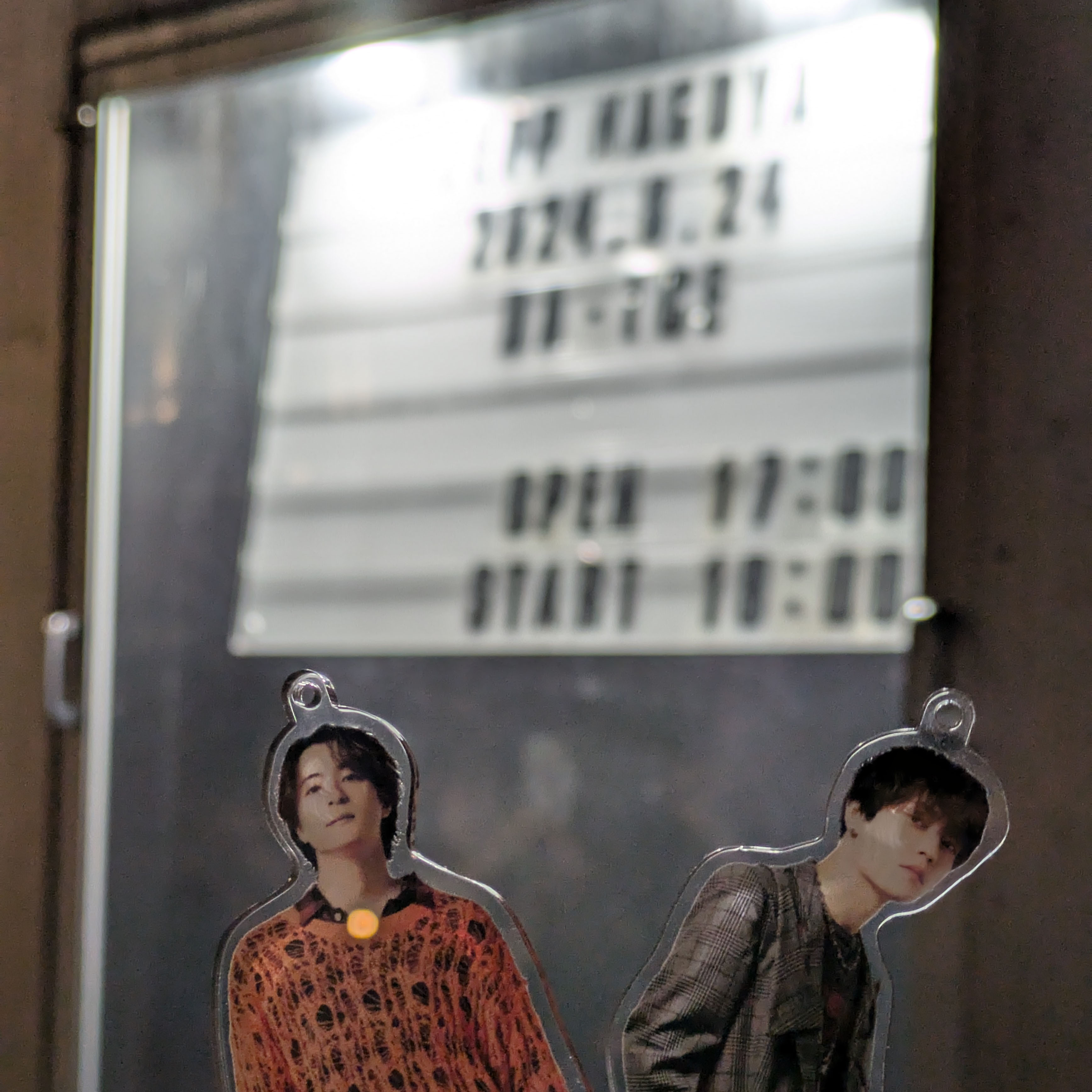 出演者看板前でアクリルスタンドを持った写真